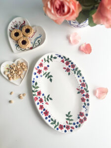 blå och röda blommor längst kanten på ett ovalt porslinsfat