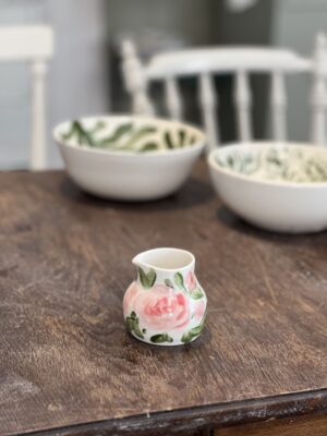 Liten kanna rosa blommor